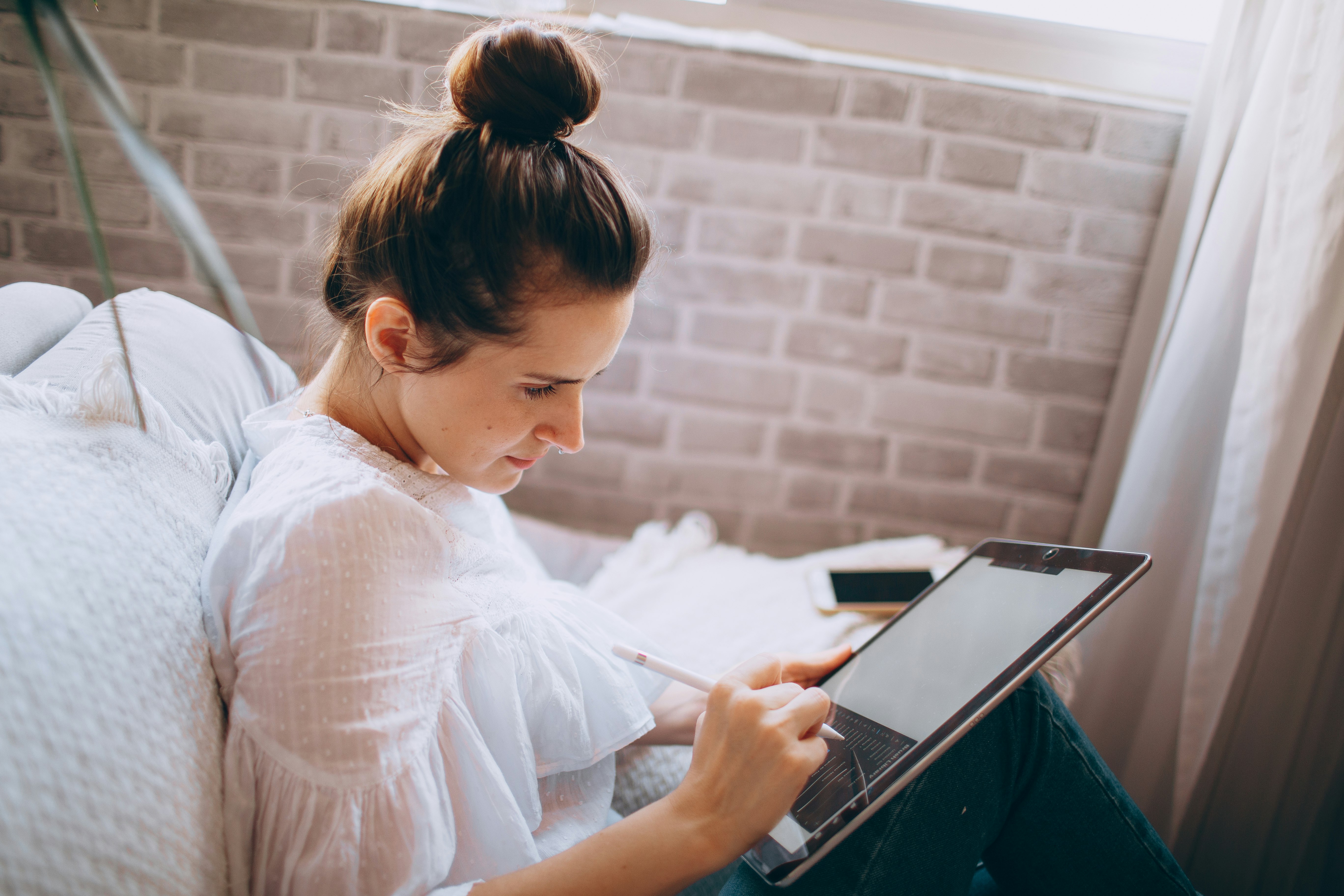 woman in white shirt holding black and silver laptop computer